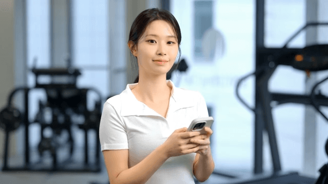 헬스장에서 스마트폰을 사용하는 여성