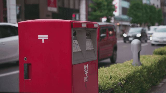 번화한 일본 도시 거리의 빨간 우체통