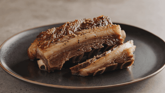 Grilled ribs on a black plate