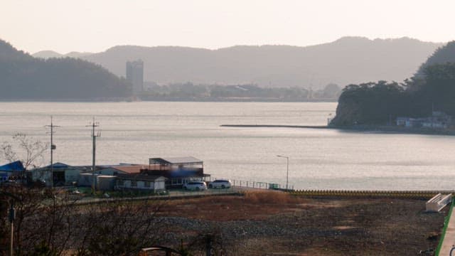 Quiet village landscape with mountains and the sea in the background