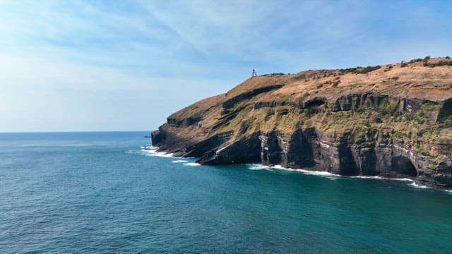 Lighthouse on a cliff by the sea