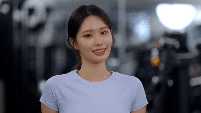 헬스장에서 정면을 보고 미소 짓는 젊은 여성