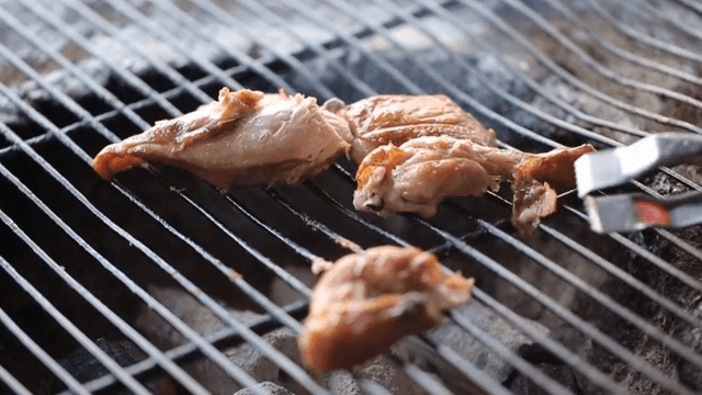 Grilled chicken pieces on a barbecue