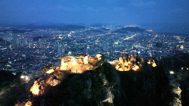 Cityscape with illuminated mountains at dusk