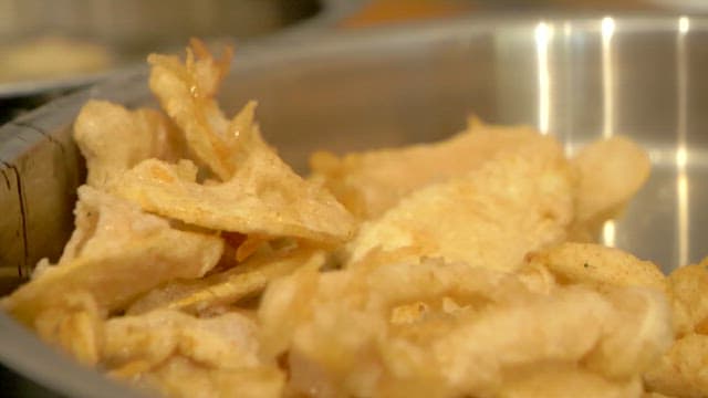 Crispy fried ginseng in a metal bowl