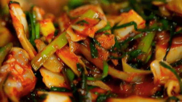 양념된 다양한 채소와 오징어를 섞는 모습