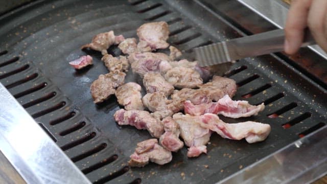 Eating Meat Grilled on a Grill at a Restaurant