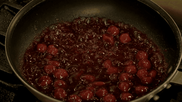Cherries simmering in a pan with sauce
