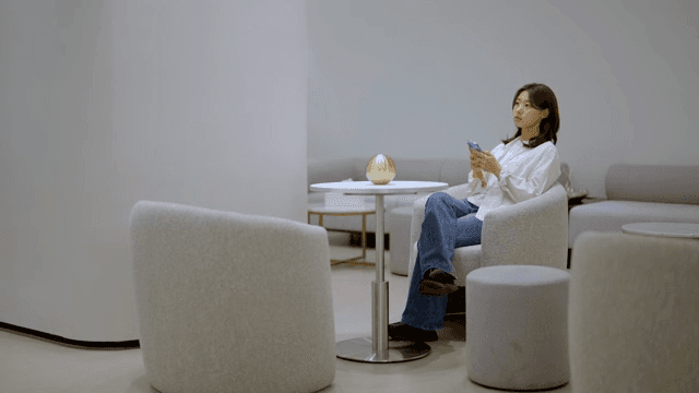 현대적인 라운지에서 스마트폰을 하며 기다리는 여성