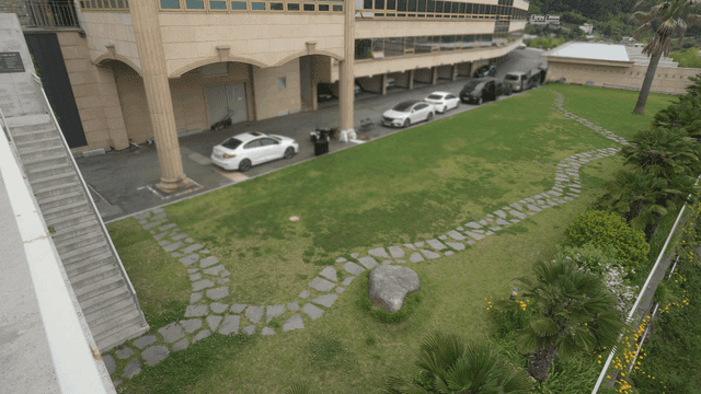 녹색 잔디와 주차된 차가 있는 건물