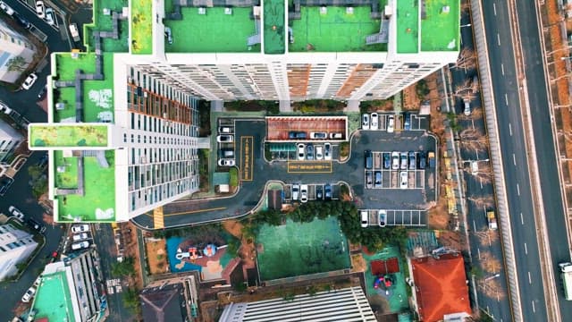 건물의 녹색 옥상과 붐비는 도로가 보이는 전망