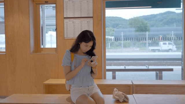 기차역에서 휴대폰을 사용하는 여성