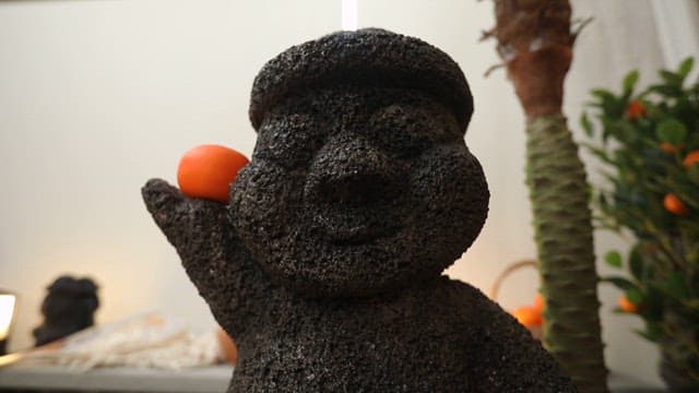 돌하르방 조각상이 놓인 테이블 위에 전시된 무와 소라