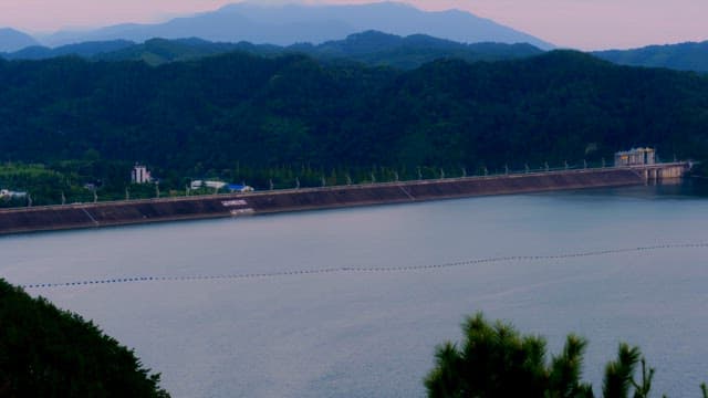 Tranquil lake with a dam and mountains