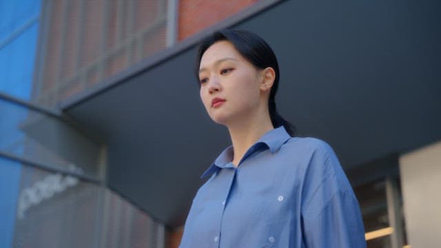 Woman looking up outside a building