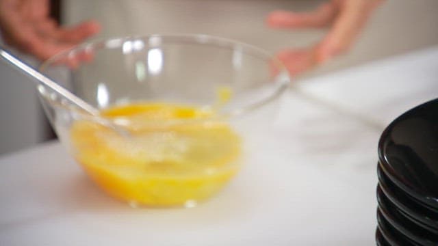 Pouring egg mixture into an oiled frying pan