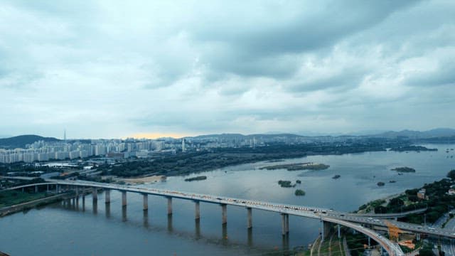 아파트가 보이는 강 위의 자동차들이 지나가는 다리