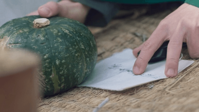 편지를 호박으로 고정하는 손