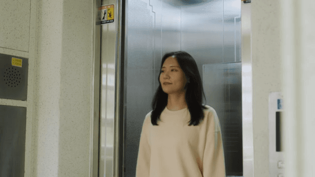 아파트 건물의 엘리베이터에서 내리는 두 사람