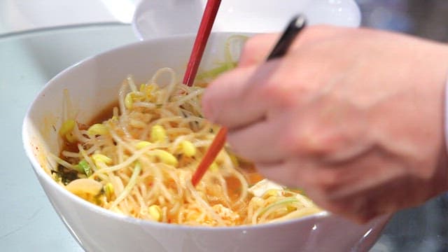 Stirring bean sprouts ramyeon with chopsticks