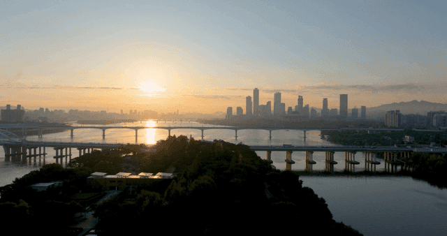 다리와 함께 도시 스카이라인 위로 떠오르는 해