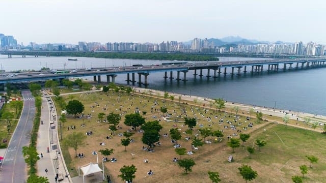 Cars Rushing by People Enjoying a Picnic