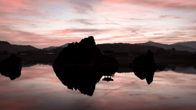 Silhouette of rocks and pavilion at sunset