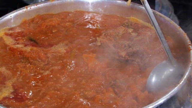 Boiling pork backbone stew stirred with a ladle