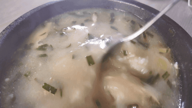 Chicken soup stirred with spoon