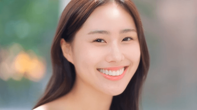 정면을 바라보고 자신감 넘치는 미소를 짓는 여성