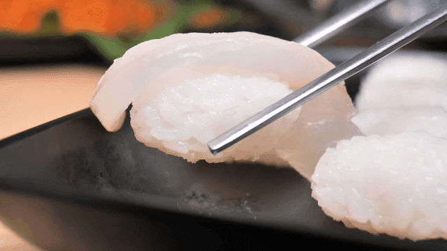 Sushi being picked up with chopsticks