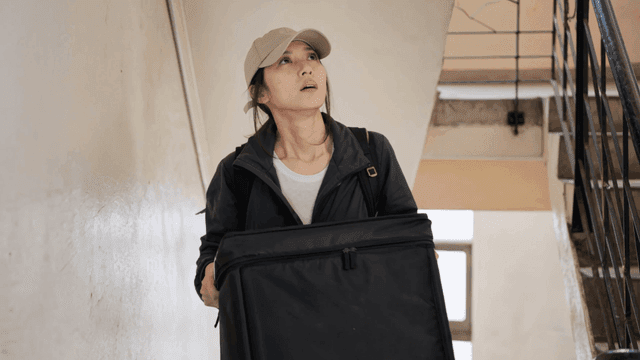 계단을 오르는 여성 배달원
