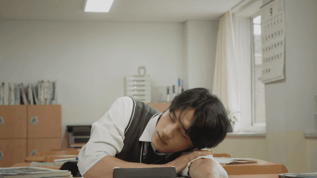 교실에서 공부하다가 하품하며 팔베고 쉬는 학생