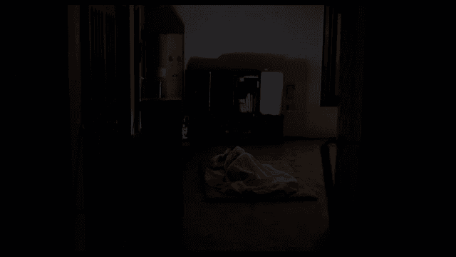 어두운 방에서 티비를 켜놓은 채 자는 사람