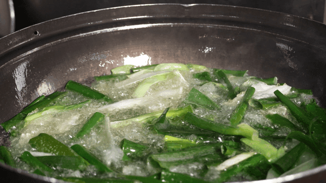 Green onions frying in hot oil