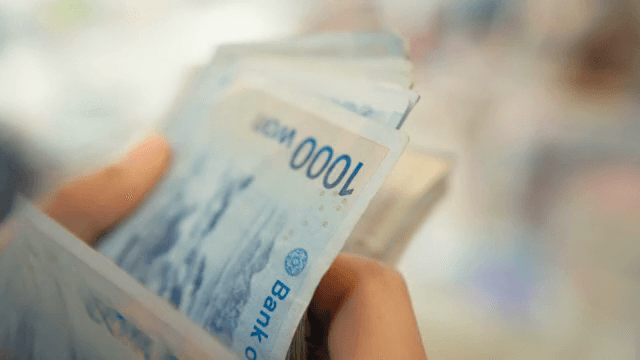 손에 든 한국 지폐를 세는 모습