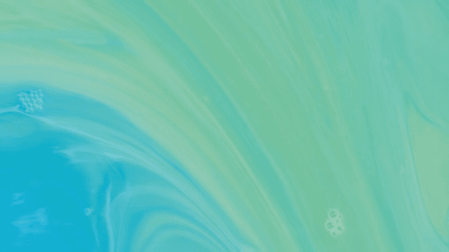 Abstract pattern of green and blue liquids mixing together