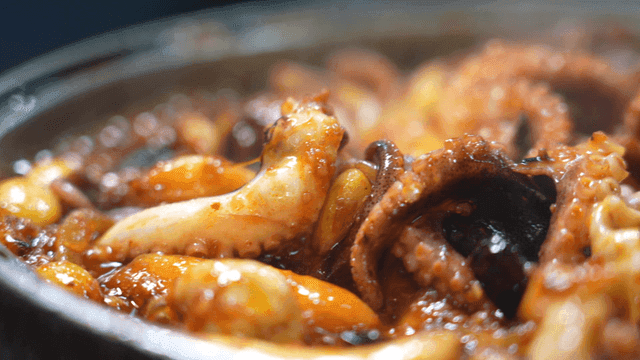 Spicy stir-fried octopus simmering in a pot