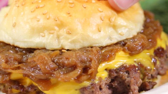 Close-up of a juicy cheeseburger with caramelized onions