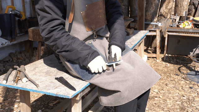 야외 작업대에서 나무를 깎는 목공예가