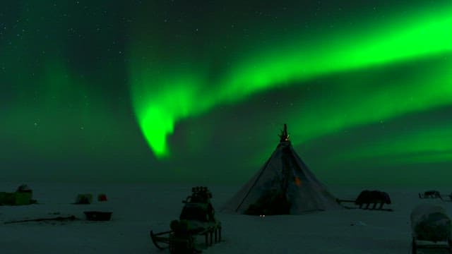 Aurora Borealis over a snowy encampment