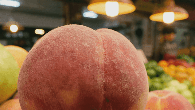 Fresh peaches displayed at a market stall