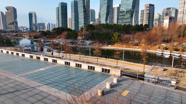 Urban park with modern skyscrapers and waterfront