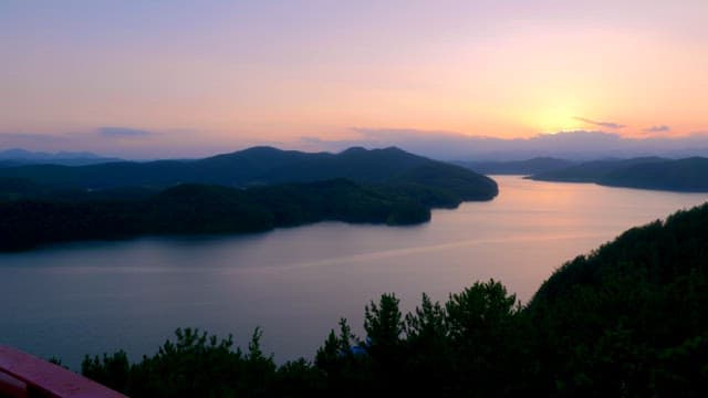 Serene lake surrounded by mountains at sunset