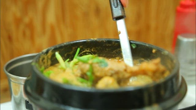 오리탕의 오리고기를 젓가락으로 집어 드는 모습