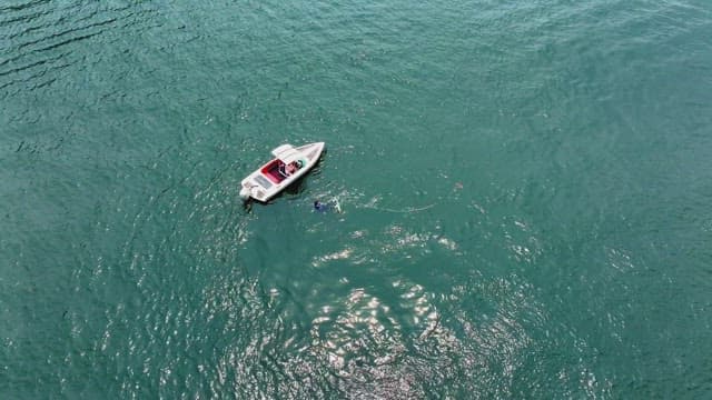 Small boat floating on a clear blue river