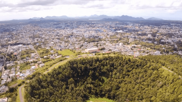 도시 근처 숲이 우거진 분화구의 항공 뷰