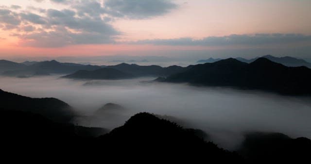 Sky Colored by Sunrise over Foggy Mountains