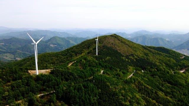 Wind turbines on a lush green mountain range