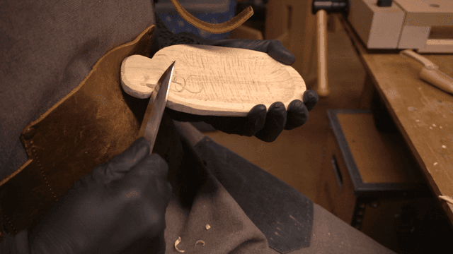 작업대에서 칼로 진행 중인 목각